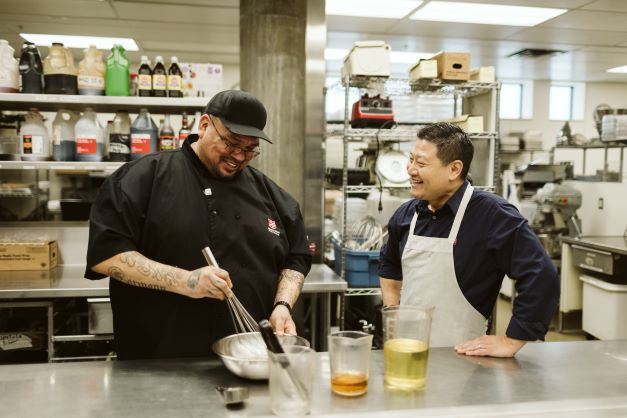 2 people cooking and smiling