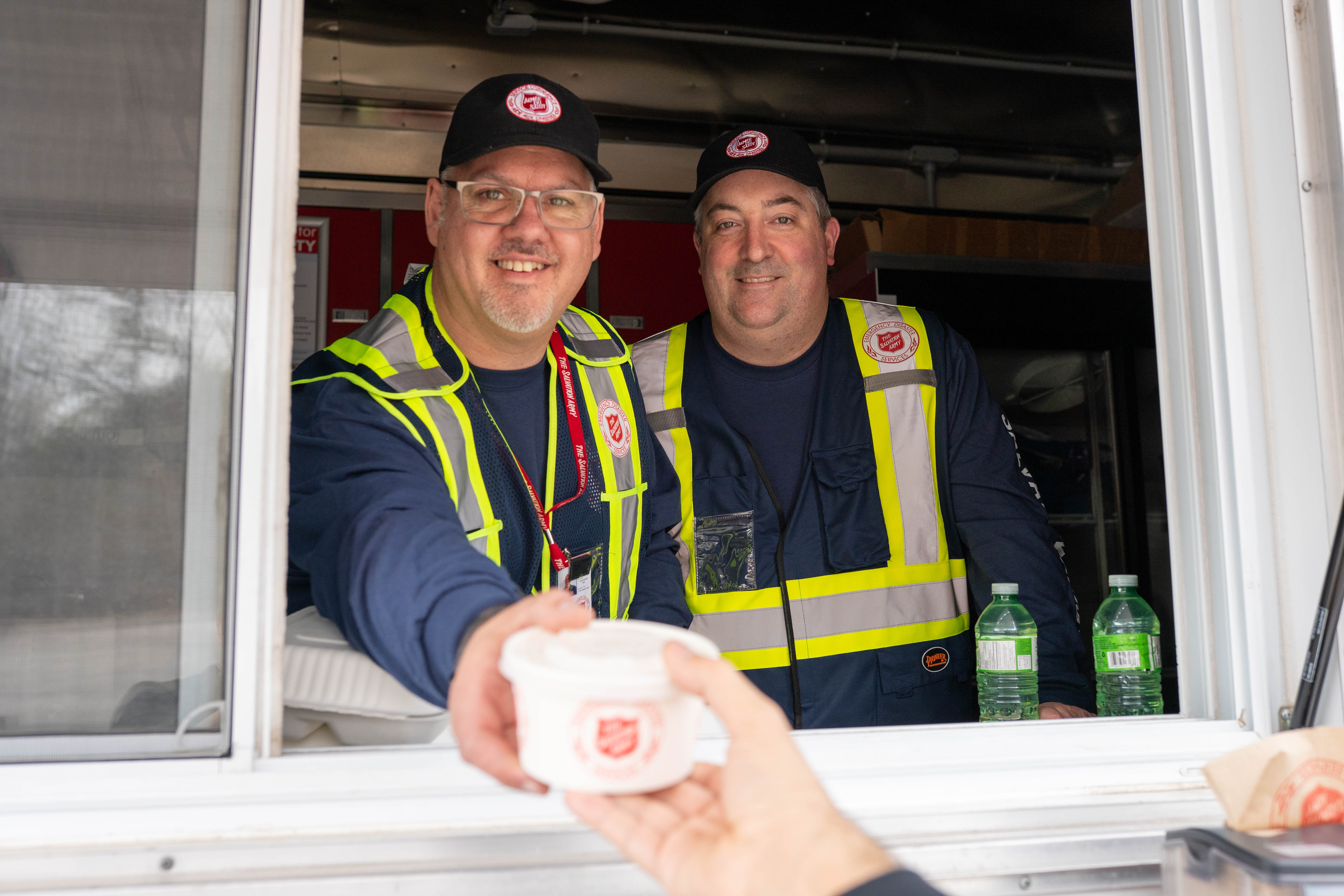 An Emergency Shelter volunteer handing warm food
