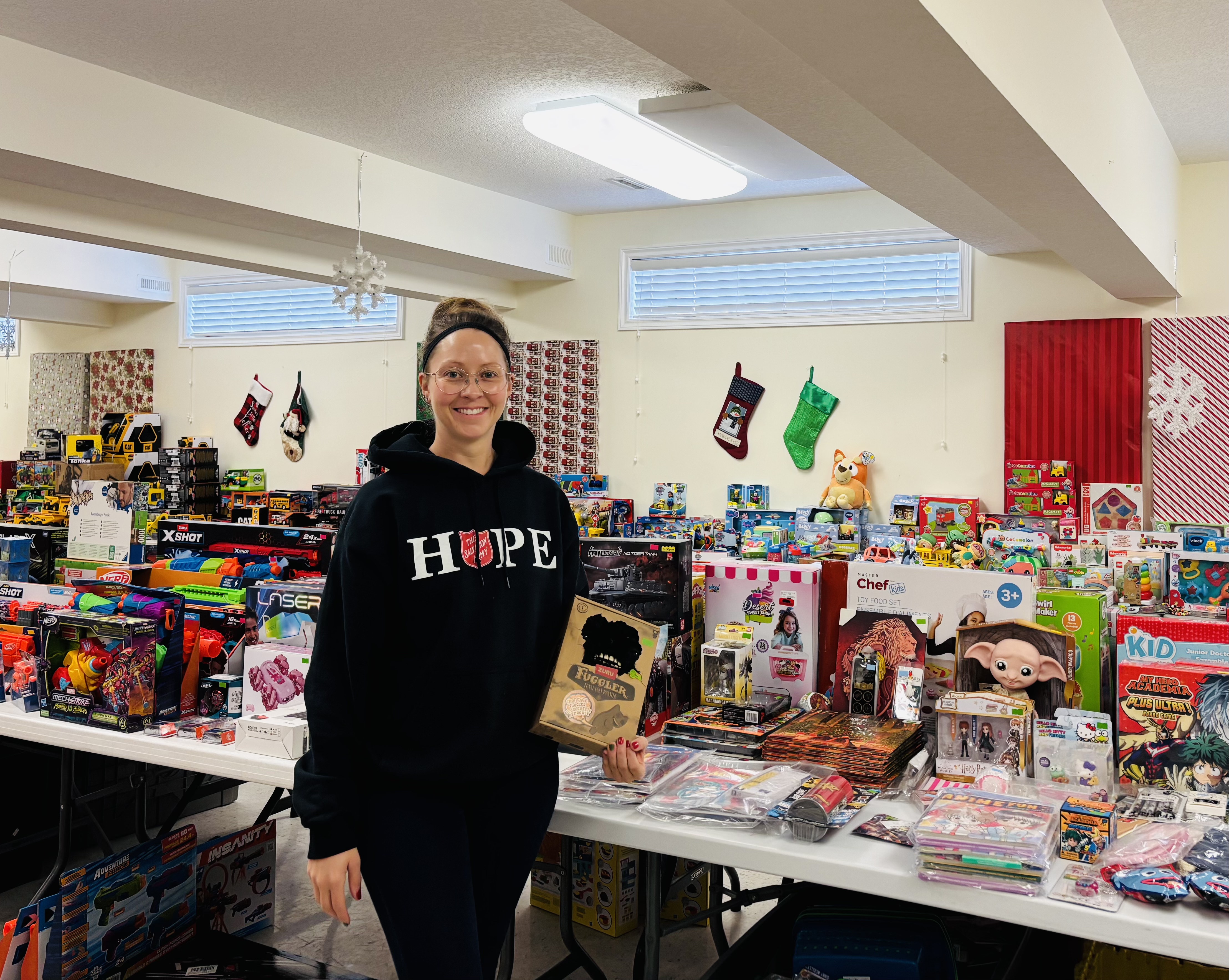 Salvation Army worker stands by table of toys