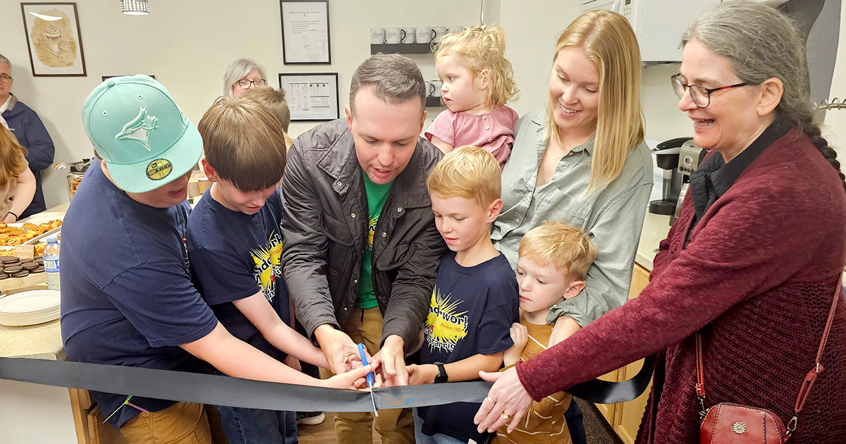 A group of people cutting a ribbon